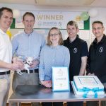 Partners with cake and trophy
